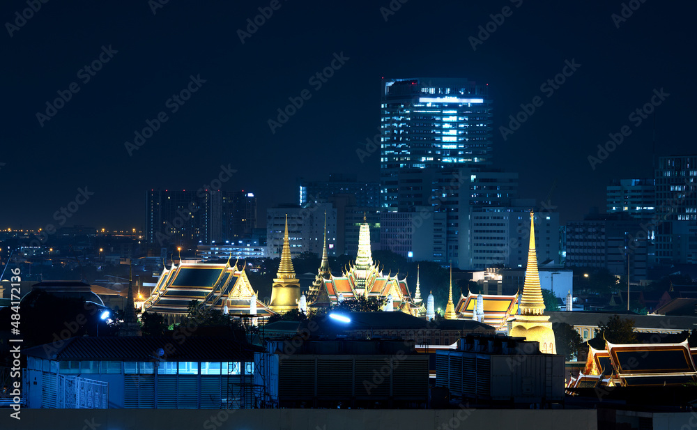 Fototapeta premium The Grand Palace illuminate gold light beatifully with surrounded buildings on night scene on blue tone color, The Grand Palace is where the royal ceremonies, Bangkok, Thailand