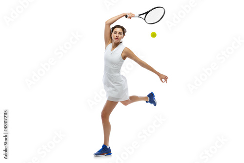 Dynamic portrait of young sportive woman, tennis player practicing isolated on white background. Healthy lifestyle, fitness, sport, exercise concept.