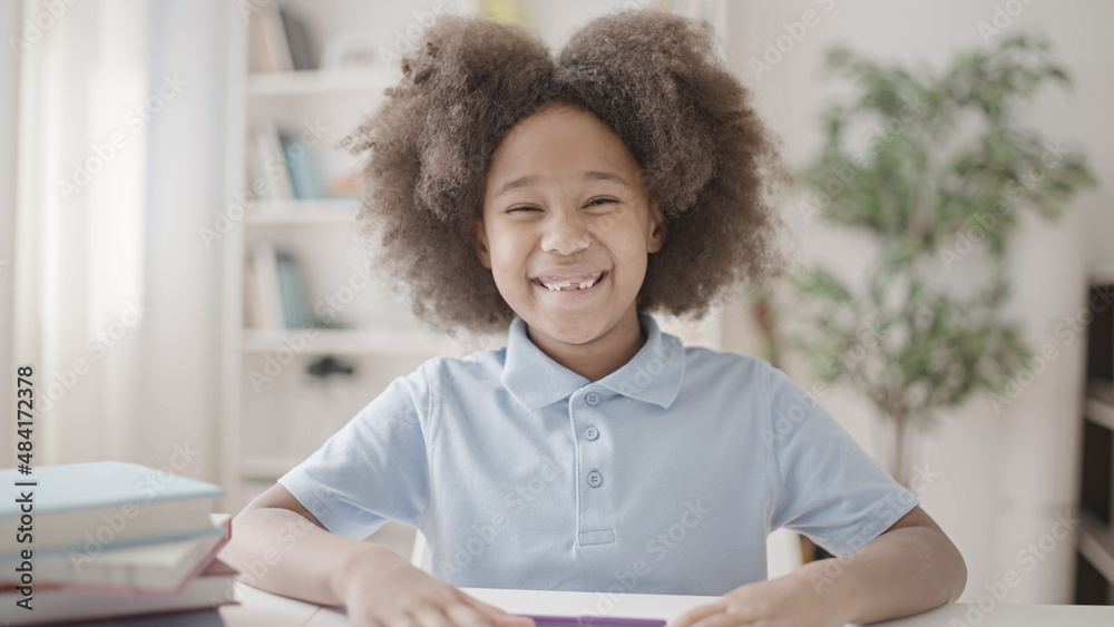 Fototapeta premium Cute positive girl with curly hair smiling on camera, child's teeth, dental health