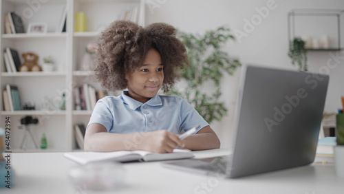 African American girl studying at home, having online video lesson on laptop