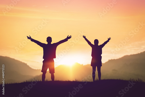 Couple rising hands on sunset sky at nature field abstract background.