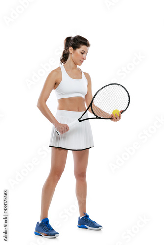 Portrait of young beautiful girl, tennis player in white sportswear posing with racket isolated on white background. Beauty, sport concept.