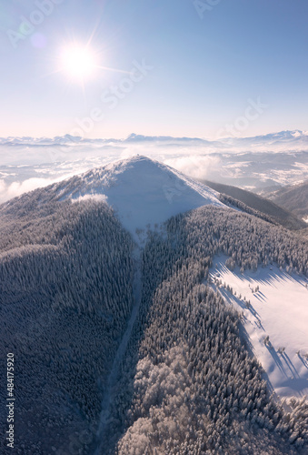 Mount Khomyak and Synyak in the Carpathians, Hoverla and Petros Chernogora on the horizon, sun rays at sunrise and sunset, fog, wild forests. Panorama from a drone. photo