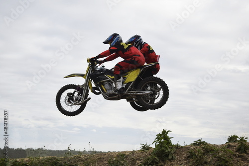 motocross bikers on motorcycles with carrycot