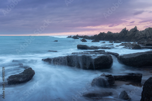 Anocheciendo con un cielo magico sobre un mar sedoso que fluye entre las rocas © APsormen
