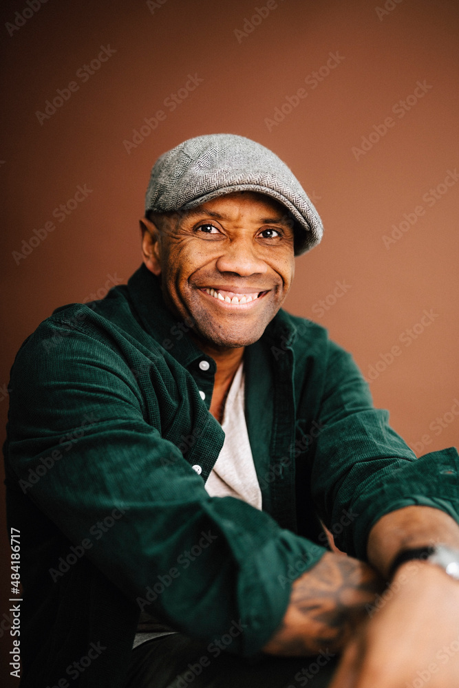Portrait of happy mature man against brown background Portrait of happy mature man against brown background