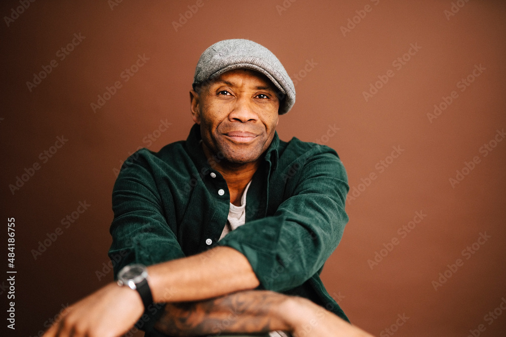 Portrait of mature man wearing beret over brown background in studio Portrait of mature man wearing beret over brown background in studio