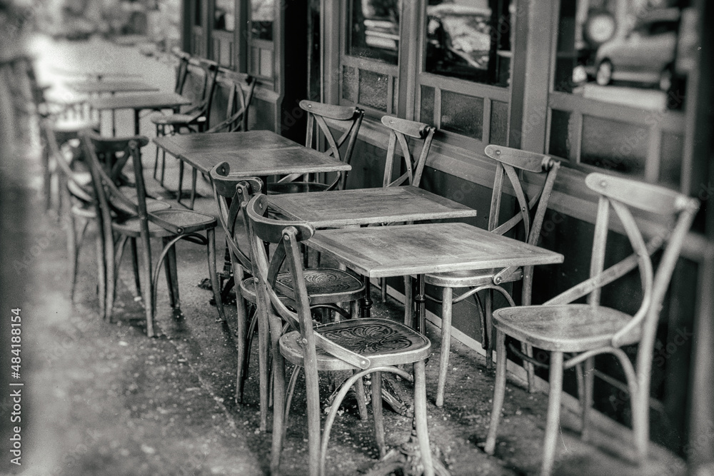 tables and chairs on the street - vintage black and white