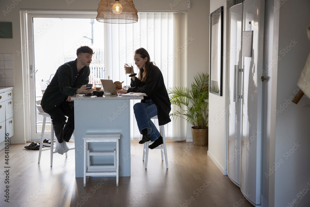 Young couple freelancing using laptop at home Young couple freelancing using laptop at home