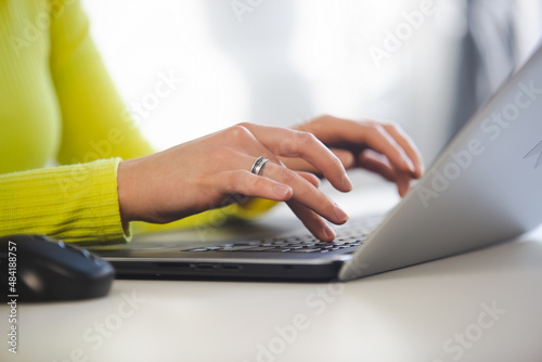 Entrepreneur woman typing on laptop keyboard. Business woman working on modern notebook pc in office. Freelance writer person doing distant work online during lockdown