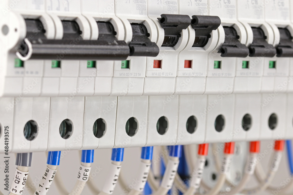 Connection of the marked mounting wires to the circuit breakers in the electrical panel in close-up.
