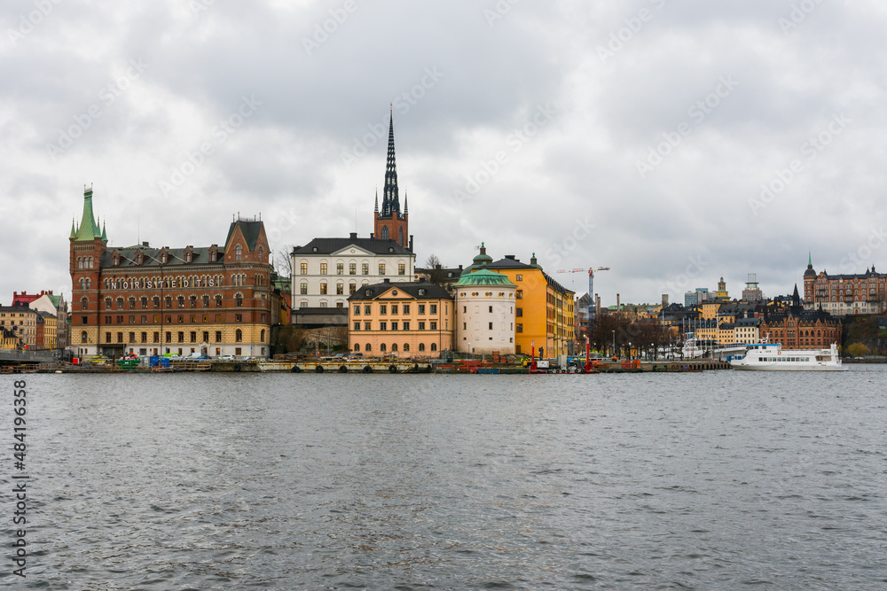 Stockholm, Sweden. Overview of Gamla Stan old town with the baltic sea in the foreground. Cloudy day in Sweden.