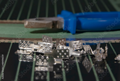 Metal clamps with teeth for connecting wires to a warm, filmy floor. There are pasatizhi in the background, blurred foreground and background - soft focus. photo