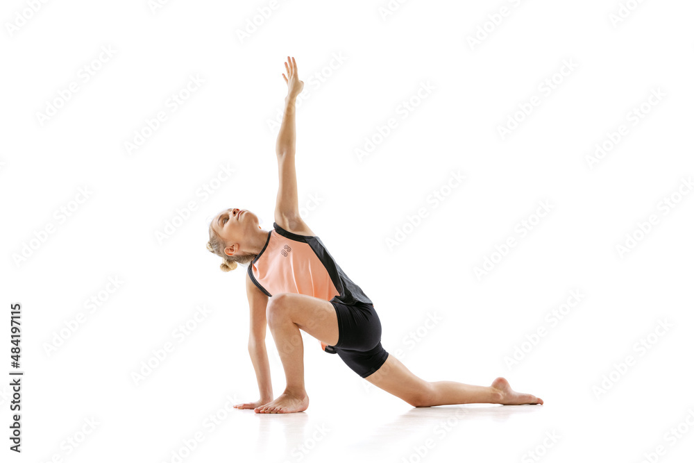 Little flexible girl, rhythmic gymnastics artist isolated on white studio background. Grace in motion, action. Doing exercises in flexibility. Little flexible girl, rhythmic gymnastics artist isolated on white studio background. Grace in motion, action. Doing exercises in flexibility.