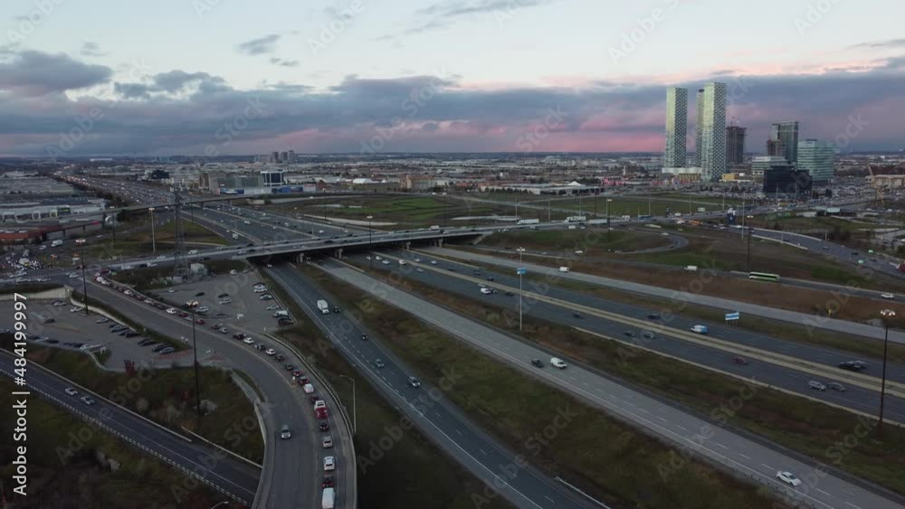 Aerial view of cars driving at crossroads. Traffic highway transportation. Business center. Multi-level junction road with moving cars at sunset. Cars are moving on a multi-level road junction Aerial view of cars driving at crossroads. Traffic highway transportation. Business center. Multi-level junction road with moving cars at sunset. Cars are moving on a multi-level road junction