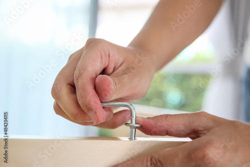 Bilde på lerret Assembly wooden furniture at home using screw allen