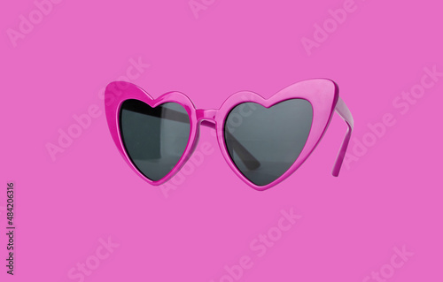 Heart shaped sunglasses on pink background. Valentine sun glasses. High quality photo