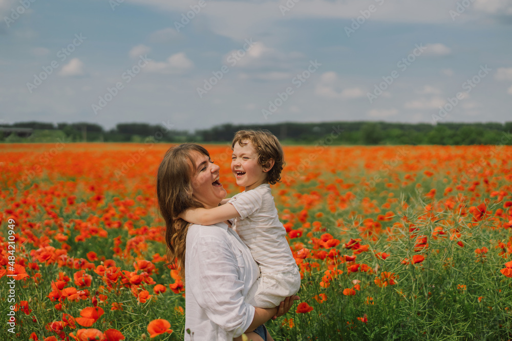 Happy Mother's Day. Little boy and mother is playing in a beautiful field of red poppies. People and nature. Rural scene Happy Mother's Day. Little boy and mother is playing in a beautiful field of red poppies. People and nature. Rural scene