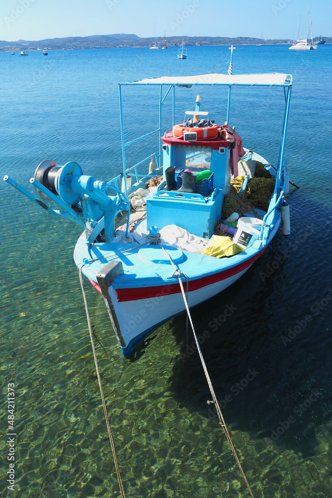 Traditional wooden fishing boat anchored in Aegean Greek island of Milos, Cyclades, Greece