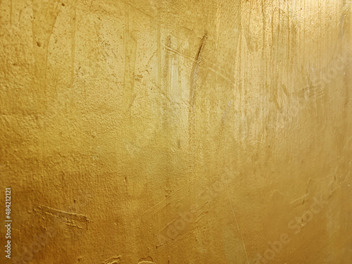 old grunge gold wall texture background with blank space for design (focus at center of image). gold or foil cement wall texture background. metallic wall.