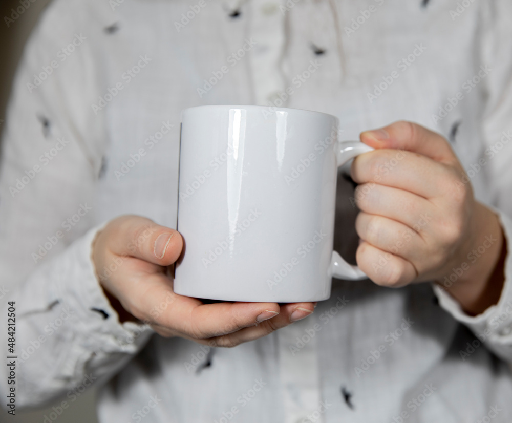 Girl holding blank white coffee mug , white porcelain mug mock up, coffee, tea, milk or soda, copy space Girl holding blank white coffee mug , white porcelain mug mock up, coffee, tea, milk or soda, copy space