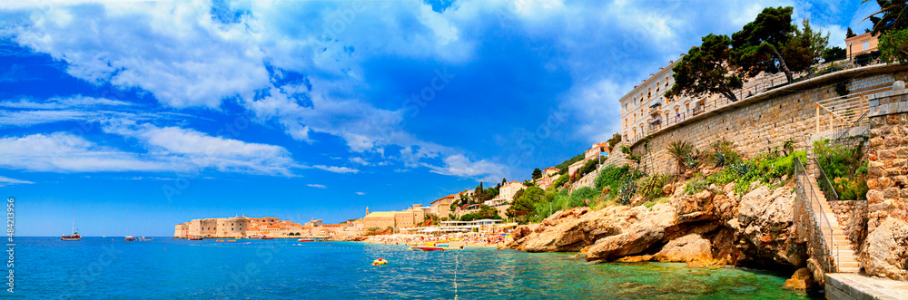 Coastal summer landscape, panorama - view of the city beach on the background of the Old Town of Dubrovnik on the Adriatic coast of Croatia