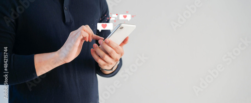 Fotografie close up young man holding smartphone while using online dating application to g