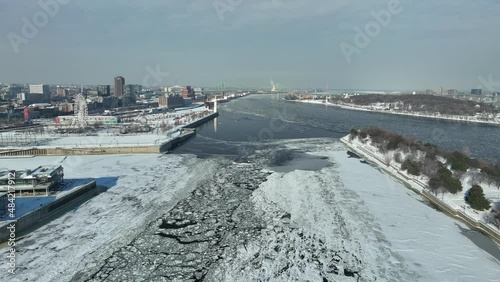 View of icy St Lawrence river and Jacques Cartier Bridge in Montreal winter photo