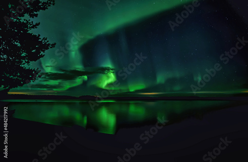 Northern lights dancing over calm lake in Farnebofjarden national park in north of Sweden. © Conny Sjostrom