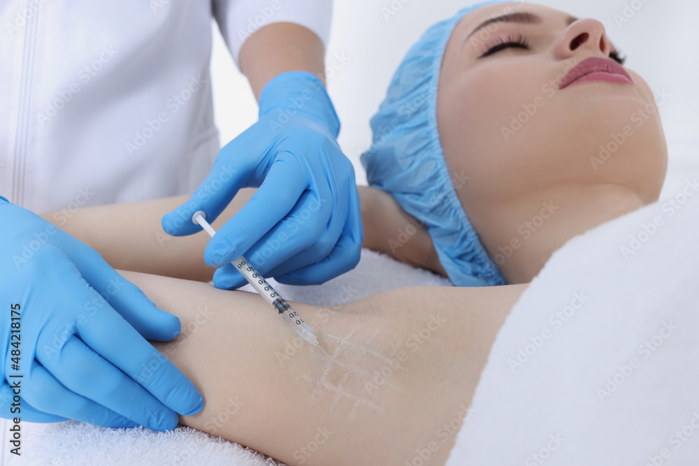 Cosmetologist injecting young woman's armpit, closeup. Treatment of hyperhidrosis