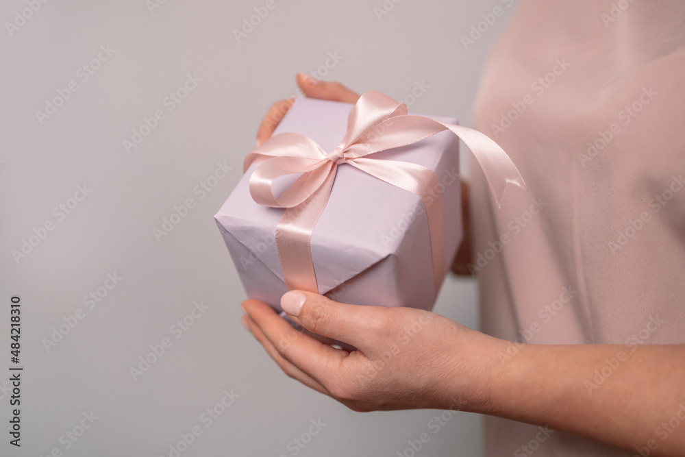 Woman holding a small purple gift box in her hands. Valentine's day celebration Woman holding a small purple gift box in her hands. Valentine's day celebration