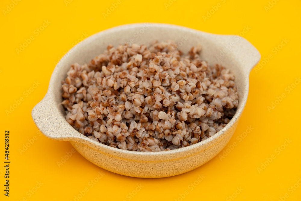 boiled buckwheat in small white bowl on yellow boiled buckwheat in small white bowl on yellow