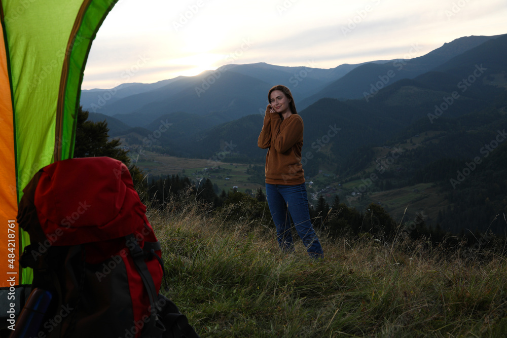 Young woman in mountains, view from camping tent