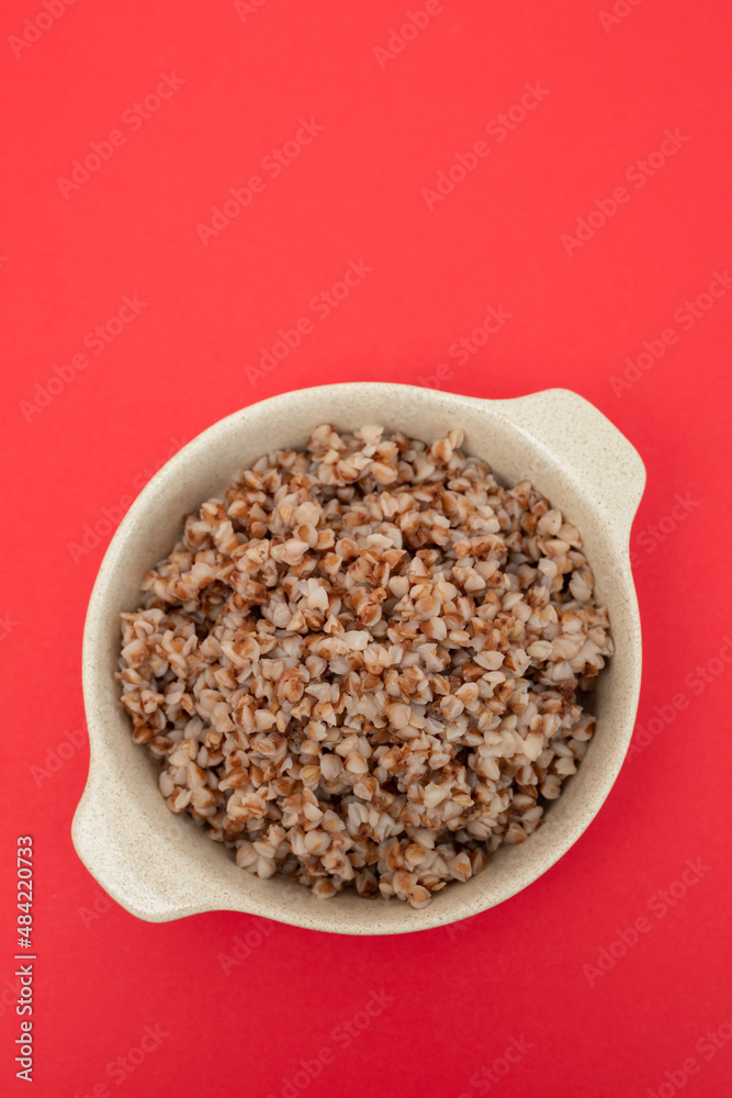 boiled buckwheat in small white bowl on red