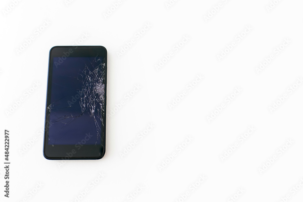 Black mobile phone with a broken screen on a white background close-up. Black smartphone with cracks and scratches on the screen after being dropped or hit does not work and needs to be repaired Black mobile phone with a broken screen on a white background close-up. Black smartphone with cracks and scratches on the screen after being dropped or hit does not work and needs to be repaired