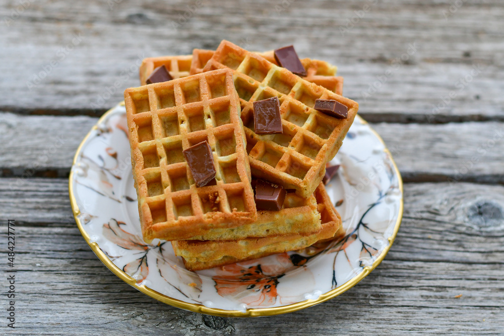 Traditional Belgian waffles with chocolate on a plate on wooden background Traditional Belgian waffles with chocolate on a plate on wooden background