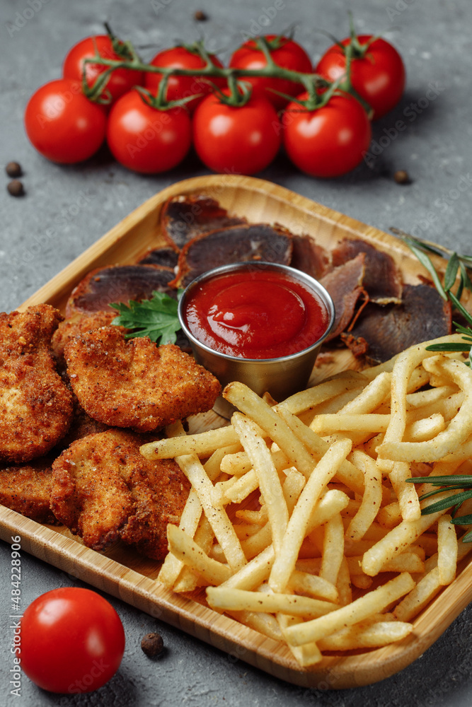 plate with snacks. breaded chicken nuggets, fried potatoes and jamon plate with snacks. breaded chicken nuggets, fried potatoes and jamon