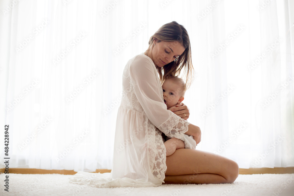 Young mother breastfeeding her newborn baby boy at home Young mother breastfeeding her newborn baby boy at home