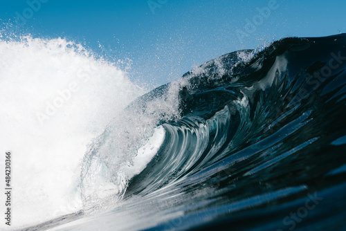 Blue wave splashing on a beach in summer © Cavan