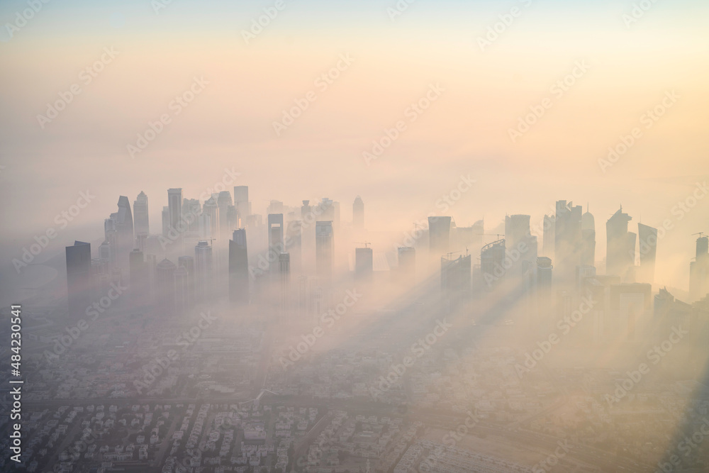 Fototapeta premium Doha skyline at sunrise with morning fog