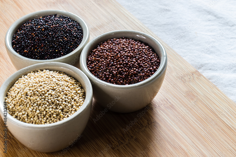 Red, black and white quinoa seeds on wooden background. Vegetarian food Red, black and white quinoa seeds on wooden background. Vegetarian food