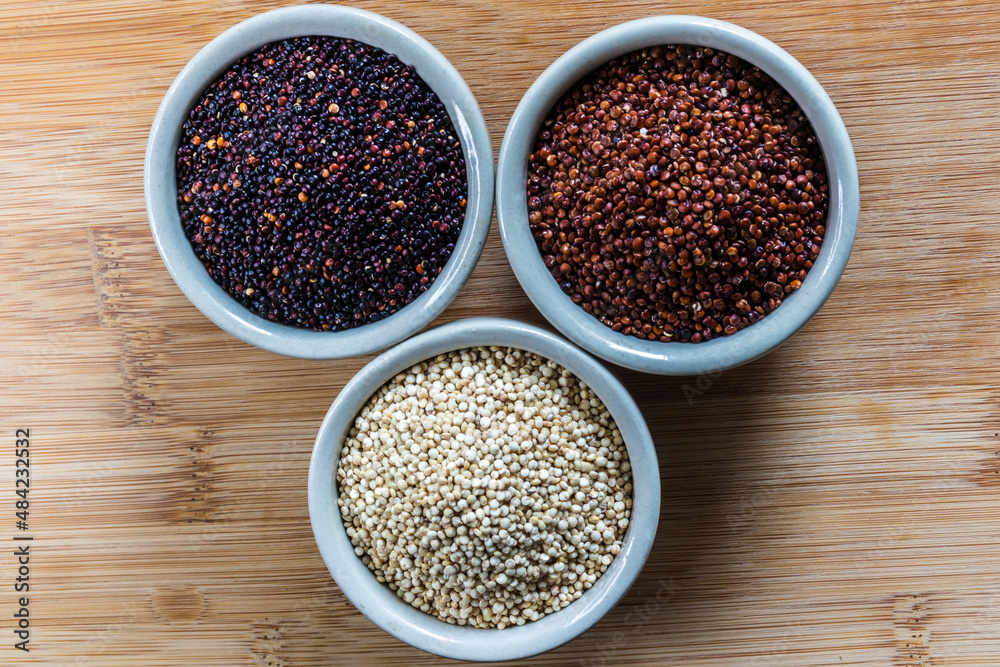 Red, black and white quinoa seeds on wooden background. Vegetarian food Red, black and white quinoa seeds on wooden background. Vegetarian food