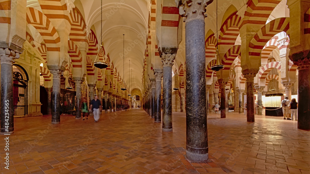 Long exposure view with motion blurred people of the arcaded hypostyle hall of the Mosque–Cathedral of Cordoba 