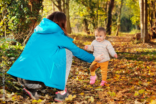 Little toddler girl making first steps in forest