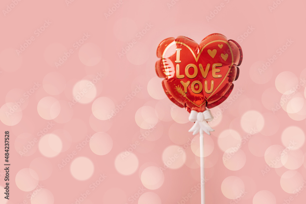 Gold I love you text inscription on red heart air balloon isolated on pink background. Valentine day