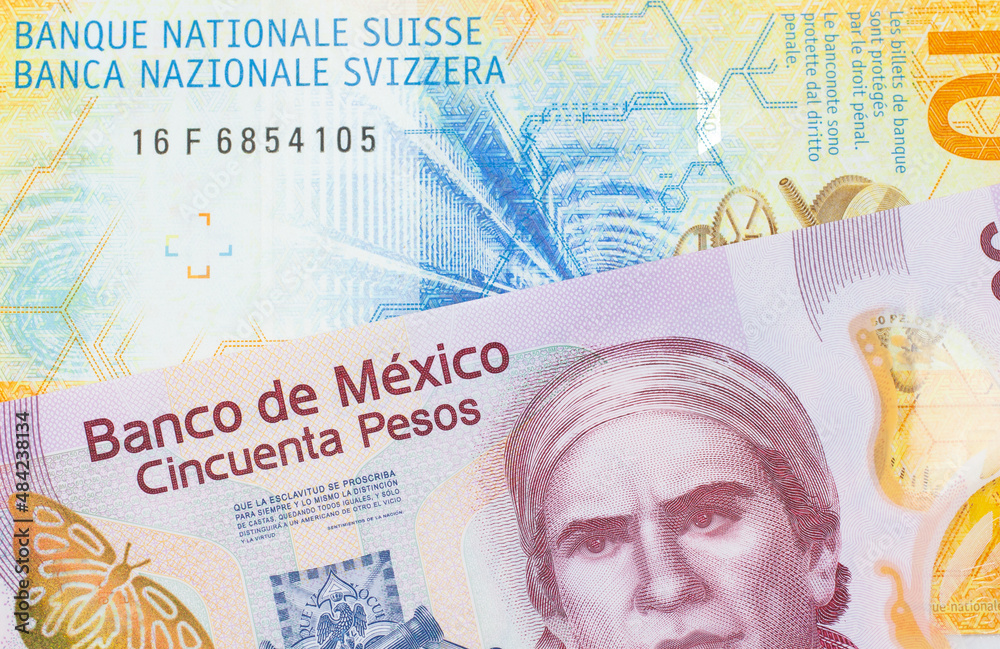 Fototapeta premium A macro image of a pink, plastic fifty peso bank note from Mexico paired up with a yellow Swiss ten franc bill. Shot close up in macro.