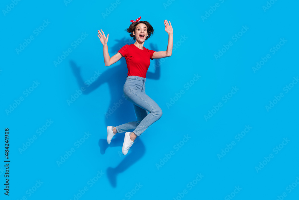Full body profile side photo of young excited woman have fun jump wave hi isolated over blue color background
