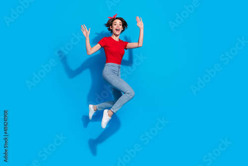 Full body profile side photo of young excited woman have fun jump wave hi isolated over blue color background