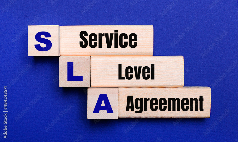 Obraz premium On a bright blue background, light wooden blocks and cubes with the text SLA Service Level Agreement