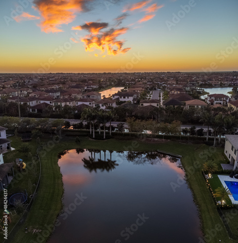 Sunset over water reflecting palm trees and houses in Parkland, Florida